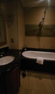 a bathroom with a bath tub and a sink at Legacy Hotel - Sandton City in Johannesburg