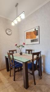 濱海帕爾姆的住宿－洛斯巴蘭德羅斯公寓，餐桌、椅子和墙上的时钟