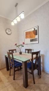 a dining room table with chairs and a clock on the wall at Apartamento Los Balandros in Palm-Mar