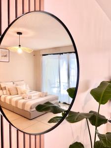 - un miroir dans une chambre avec un lit et une plante dans l'établissement Studio NEUF - PORTES DE MONACO - Confort - Wifi - Clim, à Monte-Carlo