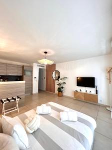 a living room with a large bed and a kitchen at Studio NEUF - PORTES DE MONACO - Confort - Wifi - Clim in Monte Carlo