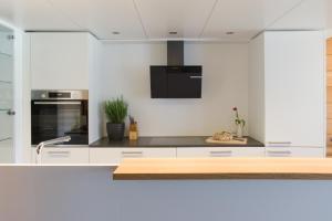 a kitchen with white cabinets and a black counter top at B31 - Ferienwohnung in Bezau in Bezau