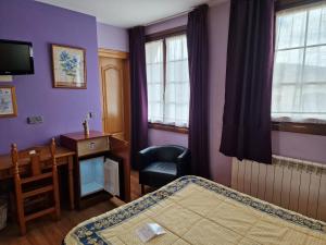 a bedroom with a bed and a desk and a chair at Hotel Virginia R.H. in Vinuesa