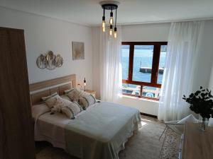 a bedroom with a bed and a large window at Piso Frente al Mar, O Barqueiro 2 in O Barqueiro