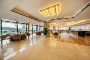 a dining room with tables and chairs and windows at Jiangshan Yunfan Sports Resort Hotel in Jiangshan