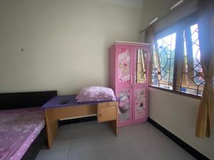 Zimmer mit einem Bett, einem Schreibtisch und einem Fenster in der Unterkunft OYO Life 93407 Kos Sweta in Tjakranegara