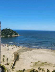 a beach with a bunch of people in the water at Studio em Santos Kitnet in Santos