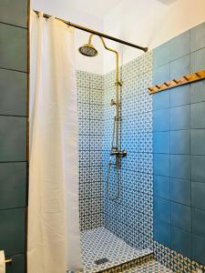 a bathroom with a shower with blue tiles at Vintage lover's getaway in Andiparos