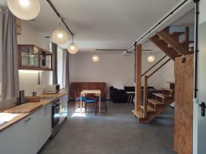 a kitchen and living room with a staircase and a table at Trafo Base Camp Apartamenty Rzędkowice in Rzędkowice