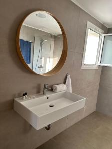a bathroom with a white sink and a mirror at Dima Vista in Dhërmi