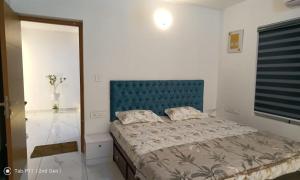 - une chambre avec un lit doté d'une tête de lit bleue dans l'établissement Sreedhanya vantage point, à Trivandrum