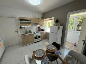 cocina con nevera, mesas y sillas en Candi central apartments, en Neos Marmaras