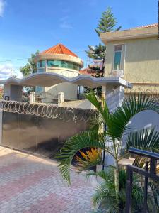 une maison avec une clôture et un palmier en face de celle-ci dans l'établissement HA LUXURY Air b&b, à Kampala