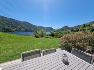 a vase sitting on a wooden deck with a view of a lake at Côté Lac Tolla in Tolla