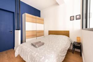 a bedroom with a white bed and a blue wall at Studio standing plein centre Aix in Aix-en-Provence