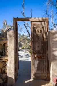 uma velha porta de madeira num edifício de pedra em Olive Garden House Siwa em Siwa