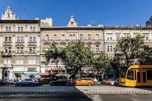 un autobus giallo parcheggiato di fronte a un grande edificio di Comfortable flat with prime location near Oktogon a Budapest