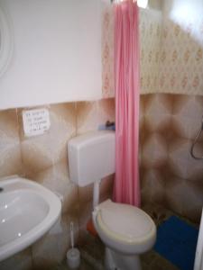 uma casa de banho com um WC branco e um lavatório. em La mia Africa em Favignana