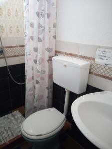uma casa de banho com um WC branco e um lavatório. em La mia Africa em Favignana