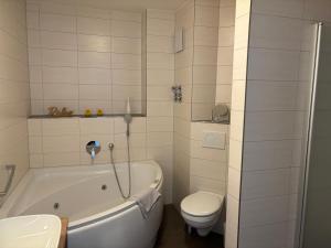 a bathroom with a white tub and a toilet at Apartment 111 in Feldberg +29 photos