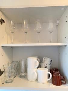 un estante con copas de vino y tazas. en Appartment nähe Linz en Puchenau
