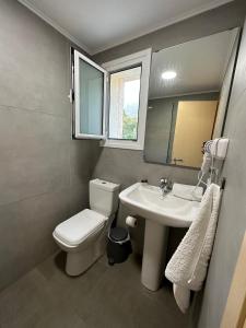a bathroom with a toilet and a sink at Dima Vista in Dhërmi