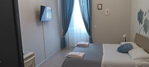 ein kleines Schlafzimmer mit einem Bett und einem TV in der Unterkunft F.A.M. ROOMS in Ciampino