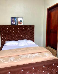 ein Bett mit einem braunen Kopfteil in einem Schlafzimmer in der Unterkunft HA Luxury Air B&B in Kampala