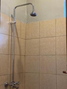 eine Dusche mit Duschkopf an einer gefliesten Wand in der Unterkunft HA Luxury Air B&B in Kampala