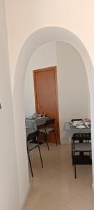 łukowy ze stołem i krzesłami w pokoju w obiekcie F.A.M. ROOMS w Ciampino