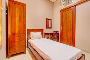 Schlafzimmer mit einem Bett und einem Holzschrank in der Unterkunft OYO Life 93497 Griya Kost Rr in Salatiga