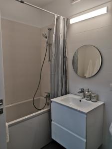ein weißes Badezimmer mit einem Waschbecken und einem Spiegel in der Unterkunft City Center Accommodation - 108 in Reşiţa