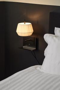 a lamp on a wall next to a bed at Hotell Slottsgatan in Oskarshamn