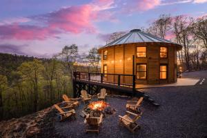 una grande cabina in legno con sedie e braciere di Skyline Yurt: Hot Tub~Wood Stove~WiFi~EVcharger a Front Royal