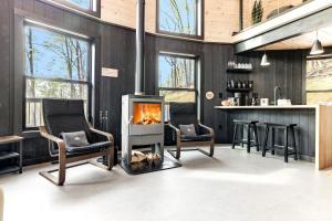 - un salon avec une cheminée et des chaises dans l'établissement Skyline Yurt: Hot Tub~Wood Stove~WiFi~EVcharger, à Front Royal