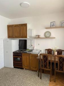 a kitchen with a table and a refrigerator and a table and chairs at Minja in Vrnjačka Banja