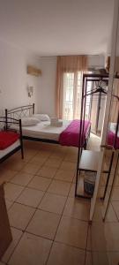 1 dormitorio con 2 literas y ventana en Delfini Hotel, en Pireo
