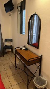 a room with a table and a mirror and a chair at Delfini Hotel in Piraeus