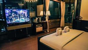 邦帕利的住宿－勒塔納酒店，一间卧室配有电视和一张饲养着两个动物的床