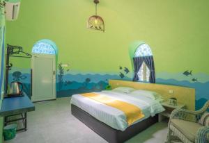 a bedroom with a bed with a painting of an ocean at Atlantis Villa Best homestay malaka in Kampong Alor Gajah