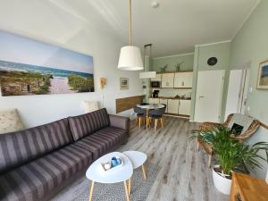 ein Wohnzimmer mit einem Sofa und einem Tisch in der Unterkunft LeinenLos im Kajüting in Dierhagen