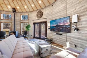 a living room with a couch and a tv at Shenandoah Yurt: Hot Tub~Wood Stove~WiFi~EVcharger in Stanley