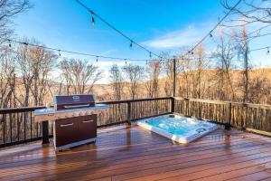 a hot tub on a deck with a grill at Shenandoah Yurt: Hot Tub~Wood Stove~WiFi~EVcharger in Stanley