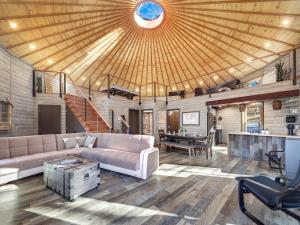 a living room with a couch and a table at Shenandoah Yurt: Hot Tub~Wood Stove~WiFi~EVcharger in Stanley