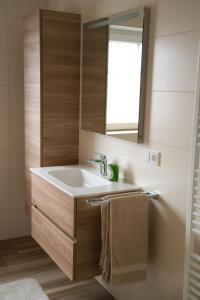 een badkamer met een wastafel en een spiegel bij Landidylle in Nalbach