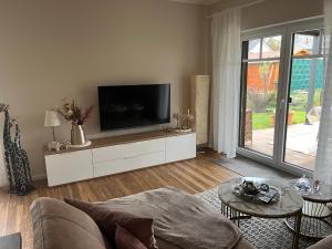 een woonkamer met een flatscreen-tv op een witte kast bij Landidylle in Nalbach