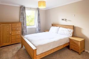 a bedroom with a bed and a dresser and a window at Gwithian Holidays in Hayle