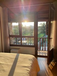 - une chambre avec un lit et une grande fenêtre dans l'établissement Maravilloso apartamento De la Santina 2B con vistas, à Avilés