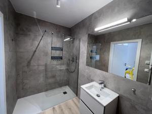 ein Badezimmer mit Waschbecken, Dusche und Spiegel in der Unterkunft Apartamenty MIW Dziwnów 21 in Dziwnów + 8 Fotos