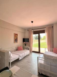 a bedroom with two beds and a large window at Lucid Dream Apt. Bozinis 2 in Psakoudia